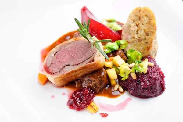 Güzel bir restoranda kızarmış ördek, kırmızı lahana rulosu ve kuru meyve.