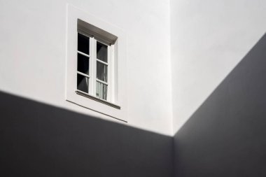 Beyaz duvarda penceresi olan beyaz bir evin gölgesi. Minimalist mimar.
