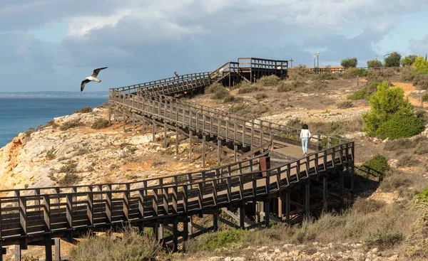 Carvoeiro, Algarve, Portuga 'daki Algar Seco geçidinde deniz kenarında egzersiz yapan yaşlı kadın.