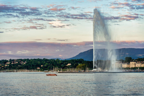 leisure boat passing by the water jet on lake Leman in the city of Geneva in Switzerlan