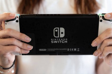 Genç kız evde Nintendo Switch ile oynuyor. Özel baskı. Seçici odaklanma.