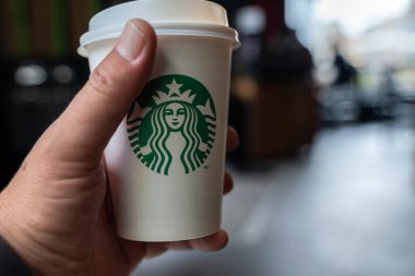 Adam elinde Starbucks kahve fincanı tutuyor.