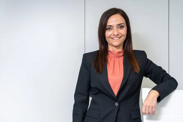 portrait of executive woman in office with white background cabinet