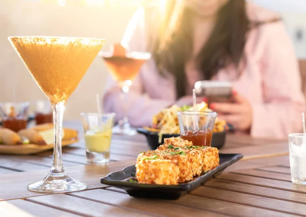 Background of multicolored drinks and minimal food - Happy hour concept with fancy cocktails and tasty appetizers served at rooftop lounge prive -  Focus on Glass