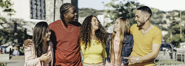 Multiracial young people walking happily on the street - Guys and girls having fun together - Lifestyle concept - Selective focus