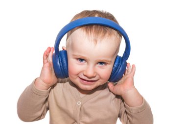 Ufaklık müzik dinliyor. Kulaklıklı çocuk beyaz arka planda izole edilmiş.