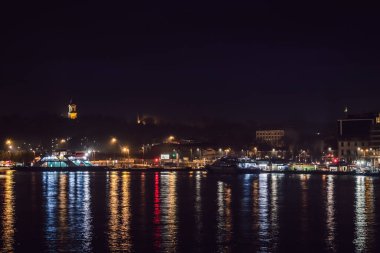 İstanbul, Türkiye, 2 Ocak 2022 - Galata Limanı 'nda gece ışıkları ve İstanbul Boğazı' ndaki yansımalarla sabah erken saatlerde seyir gemisi