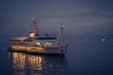 İstanbul, Türkiye, 2 Ocak 2022 - Galata Limanı 'nda gece ışıkları ve İstanbul Boğazı' ndaki yansımalarla sabah erken saatlerde seyir gemisi