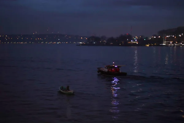 İstanbul, Türkiye, 2 Ocak 2022 - Galata Limanı 'nda gece ışıkları ve İstanbul Boğazı' ndaki yansımalarla sabah erken saatlerde seyir gemisi