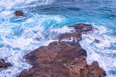 Atlantik Okyanusu 'nun suyu kayaların üzerinde kırılıyor - kayaların üzerinde su kırılıyor