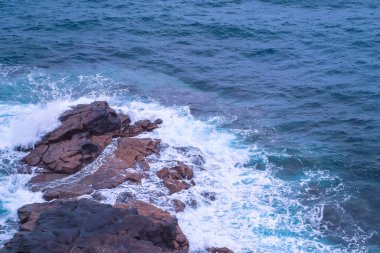 Atlantik Okyanusu 'nun suyu kayaların üzerinde kırılıyor - kayaların üzerinde su kırılıyor