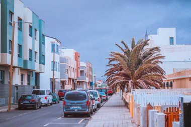 Pozo Izquierdo, İspanya, 3 Nisan 2022 - Tropikal iklimi olan bir yerleşim bölgesinde arabalar ve evler