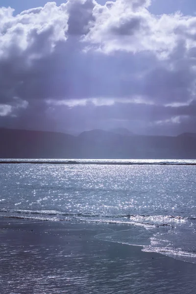 Sahilde su ve arka planda dağlar