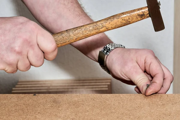 Mão com martelo martelo prego martelos ao montar móveis — Fotografia de Stock