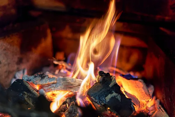 Carbones negros ardientes y fuego criado en la chimenea Imagen De Stock