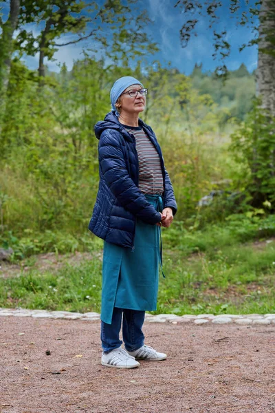 Una mujer vestida de peregrino religioso camina por un camino forestal — Foto de Stock