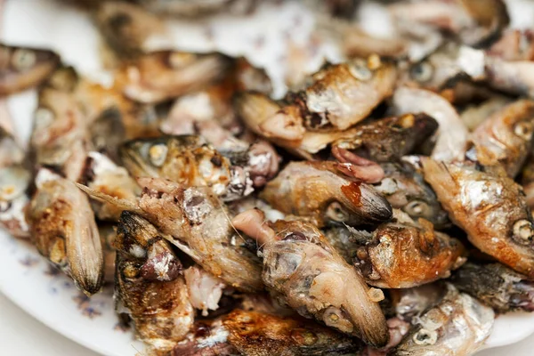 Рыбьи головы и кости, оставшиеся после еды на тарелке. — стоковое фото