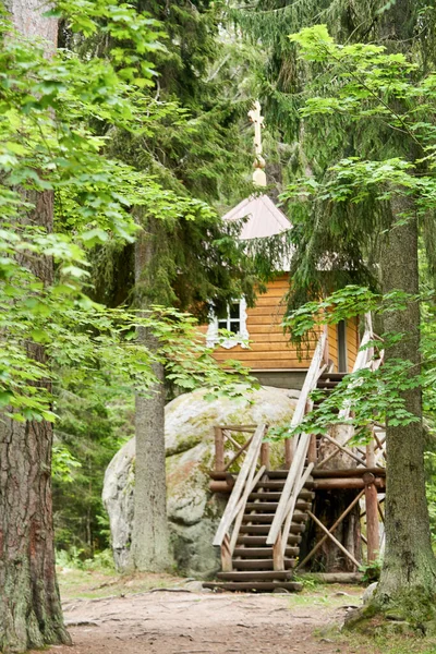 Pequeña casa de madera en una gran piedra en el bosque — Foto de Stock