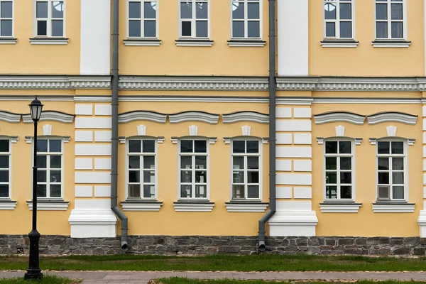 Fragment van de gevel van het paleis met ramen en een gele muur — Stockfoto
