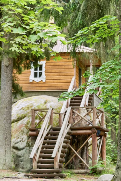 Pequeña casa de madera en una gran piedra en el bosque — Foto de Stock