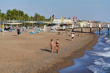 Antalya, Türkiye - 30 Ekim 2021: Deniz kıyısında turistler dinlenirken kumsal