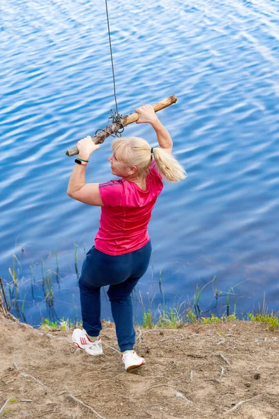 Chica en ropa deportiva se prepara para bungee saltar sobre el agua — Foto de Stock