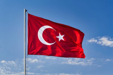 Türk bayrağı gökyüzünün arka planında rüzgarda dalgalanıyor