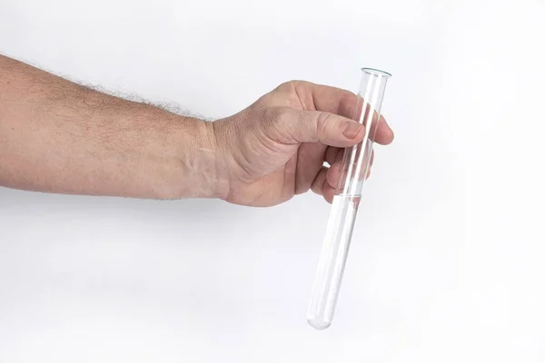 Hand holds a glass test tube with a transparent liquid on a white background — Stock Photo, Image