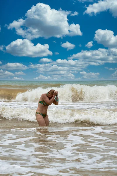 Una mujer en traje de baño con el pelo largo blanco sale del mar — Foto de Stock