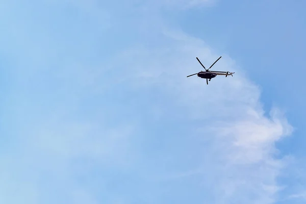 Repülő helikopter hátán a kék ég lucfenyő felhők — Stock Fotó