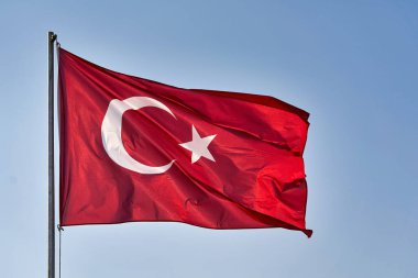 Türk bayrağı gökyüzünün arka planında rüzgarda dalgalanıyor
