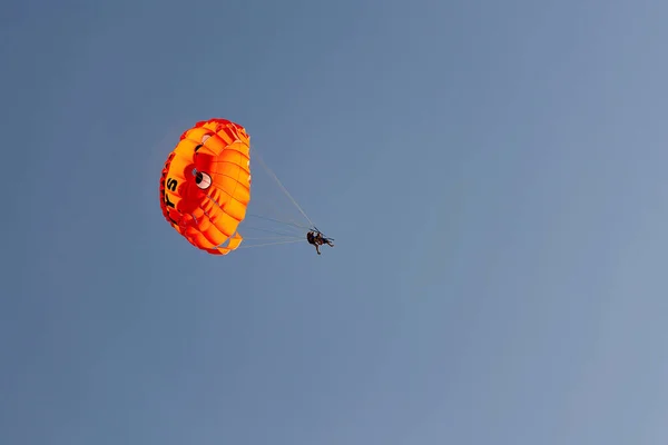 パラシュートとともに飛行男に対して青空の背景 — ストック写真