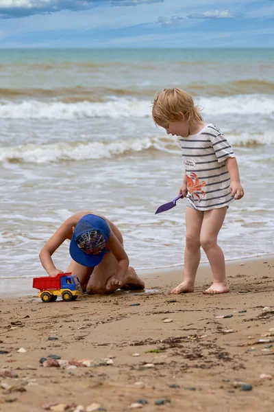 Two little boys are playing on the seashore — Stock Photo, Image