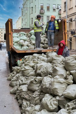 İşçiler inşaat atıklarını bir kamyona yüklüyorlar