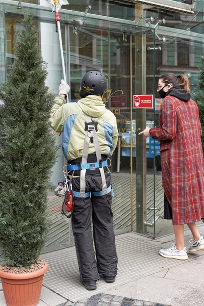 Un nettoyeur de vitres en matériel d'escalade lave la porte vitrée d'un bureau à Pétersbourg — Photo