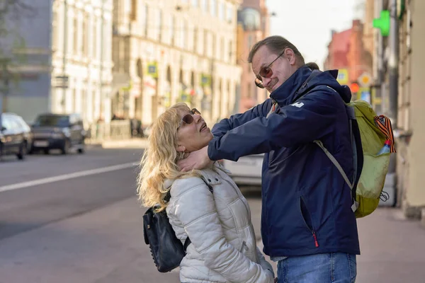 Un hombre alto con cola de caballo estrangula a una mujer en la calle con las manos —  Fotos de Stock