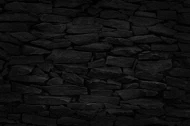 Arkaplan ve tasarım çalışmaları için doğal desenli siyah taş duvar dokusu.