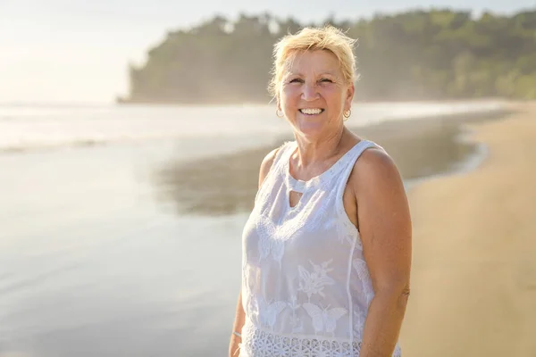 Старша жінка добре проводить час на пляжі заходу сонця — стокове фото