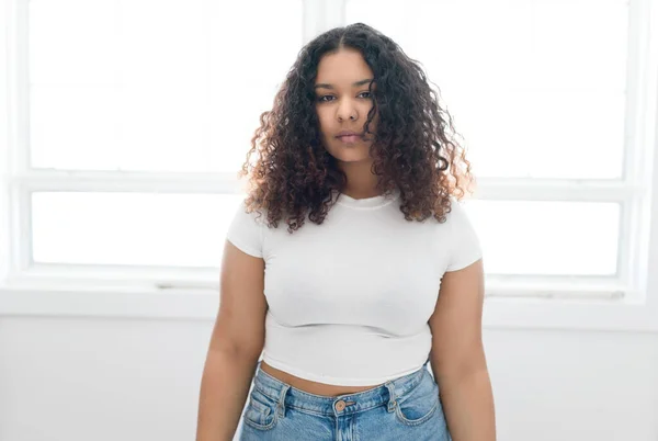 African American woman aside out window, standing at home — Stock Photo, Image