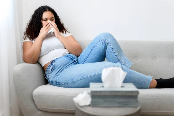 Doente mulher negra doente com tecido sentado no sofá — Fotografia de Stock