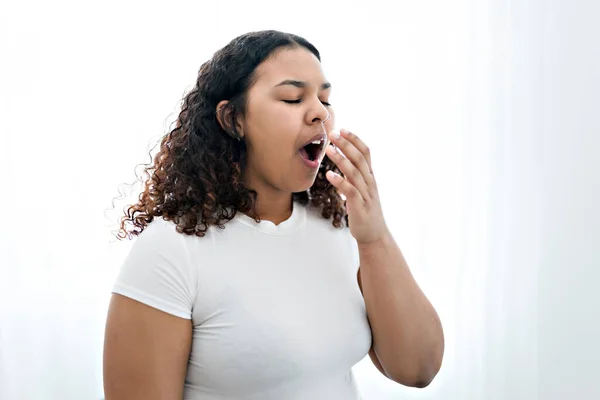 Jong Afrikaans amerikaans vrouw verveeld geeuwen moe bedekking mond met de hand — Stockfoto