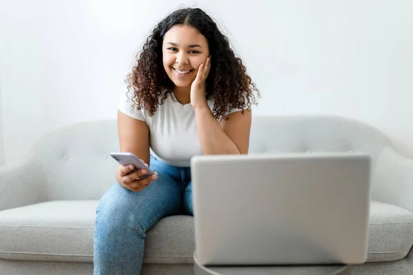 Ung afroamerikansk kvinna med bärbar dator hemma med kreditkort till hands — Stockfoto