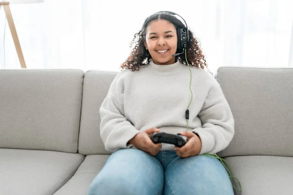 Young dark haired woman in white clothes playing video games in a living room — Stock Photo, Image