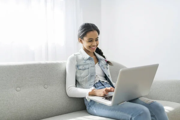 Afrikansk Teenager Pige Ved Hjælp Bærbar Computer Browsing Internet Sidder - Stock-foto