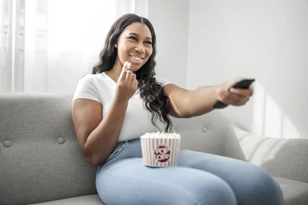 Attractive Young African Woman Sitting Couch Home Eating Popcorn —  Fotos de Stock