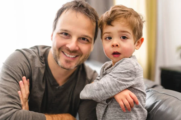 Retrato de niño con padre divirtiéndose en sofá con actitud — Foto de Stock