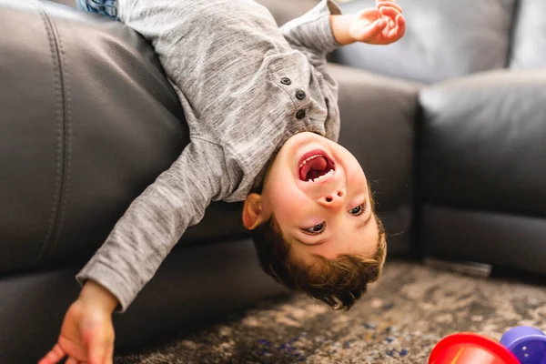 Little boy is standing on sofa at home upside down — Photo