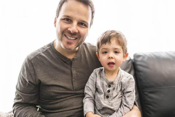 Retrato de niño sonriente con padre en el sofá — Foto de Stock