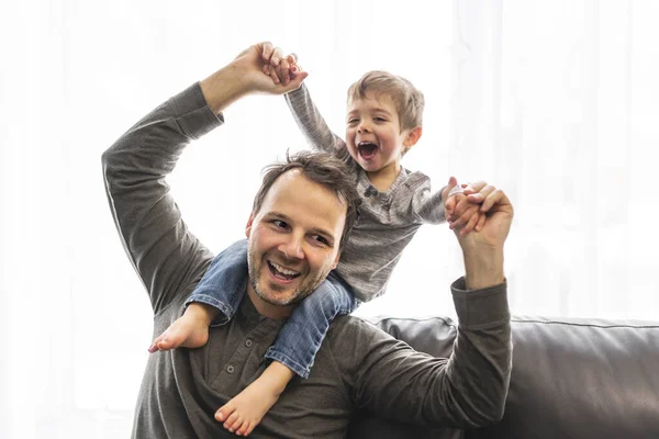 Portrait of little boy with father having fun on sofa — 스톡 사진