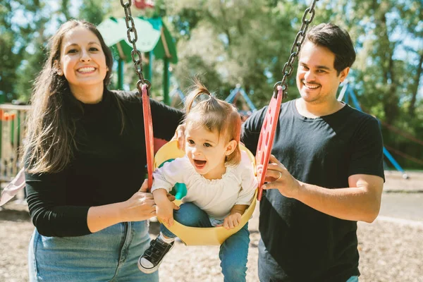 Happy family with two year sit on the swing — Stock Photo, Image